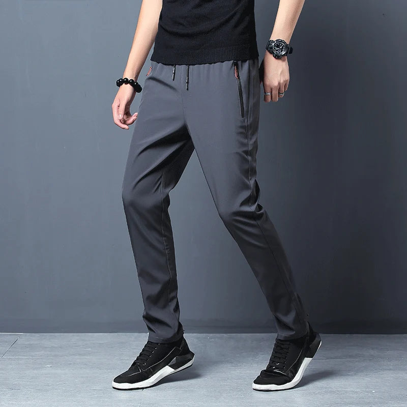 Person wearing gray pants and black shoes against a gray background