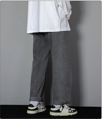 Person wearing gray pants and a white shirt against a gray background