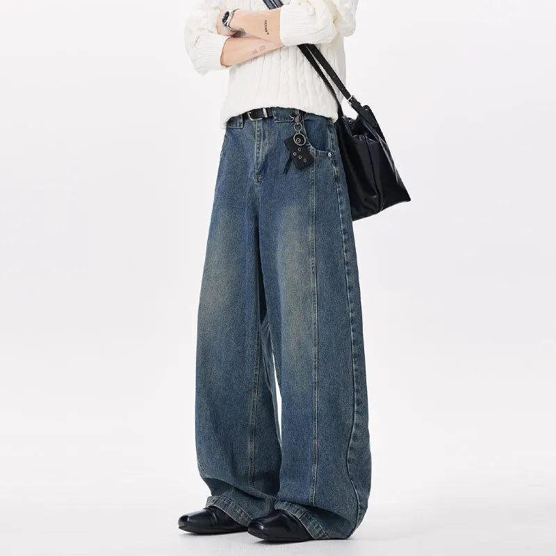 Person wearing wide-leg jeans and a white sweater on a white background