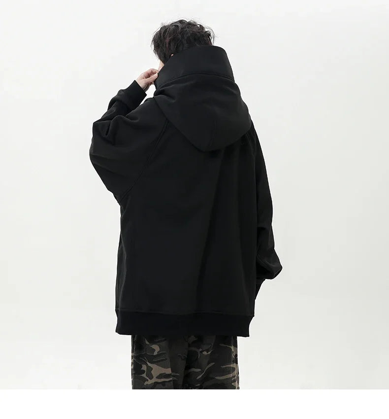 Person wearing a black oversized hoodie with camouflage pants on a white background