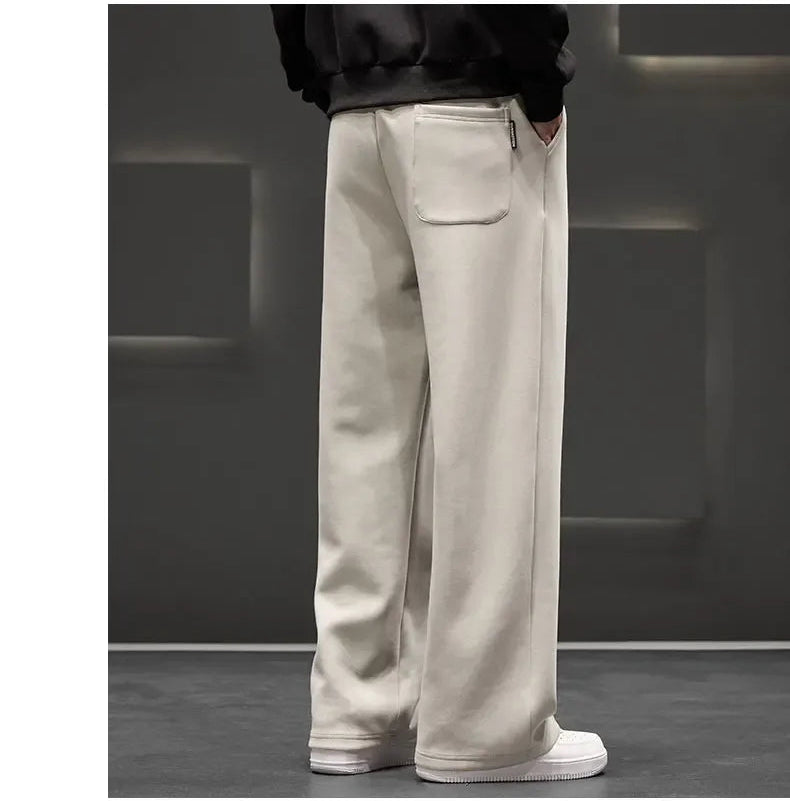 Person wearing beige pants and white shoes in a minimalistic setting