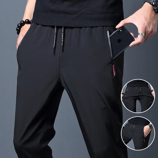 Person wearing black pants with a focus on the design details against a gray background.