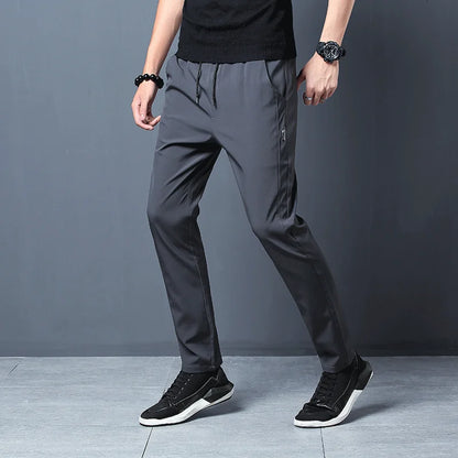 Person wearing gray pants and black shoes on a gray background