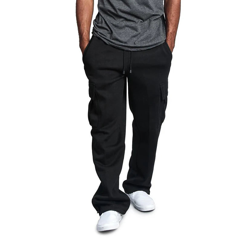 Person wearing black pants and a gray shirt on a white background