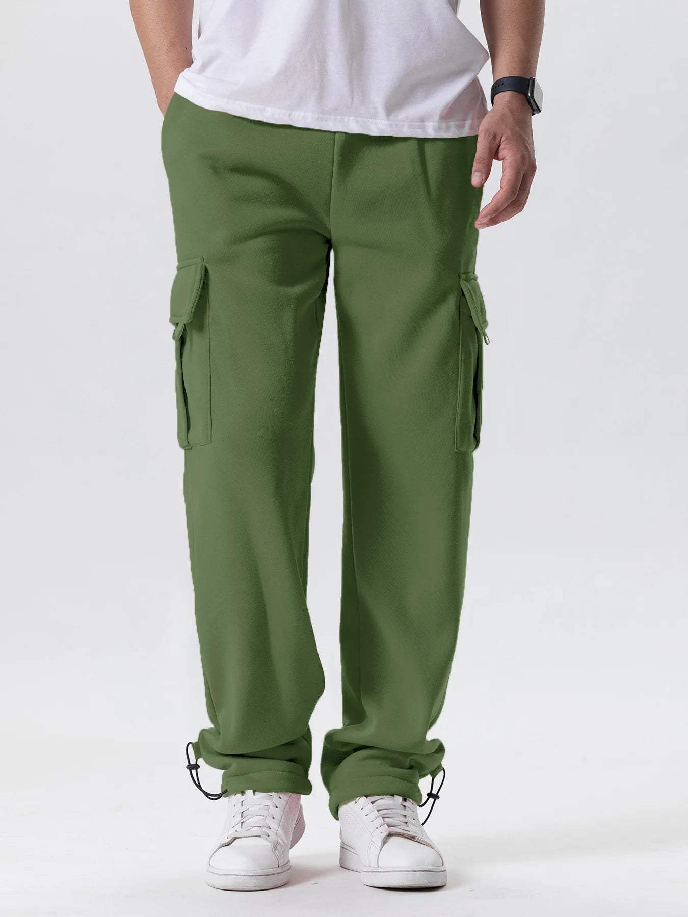 Person wearing green cargo pants and white sneakers on a white background
