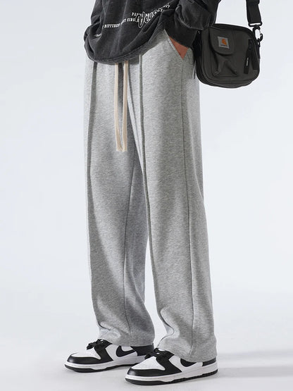 Person wearing gray sweatpants with a white background