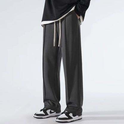 Person wearing black pants with a white drawstring on a light gray background