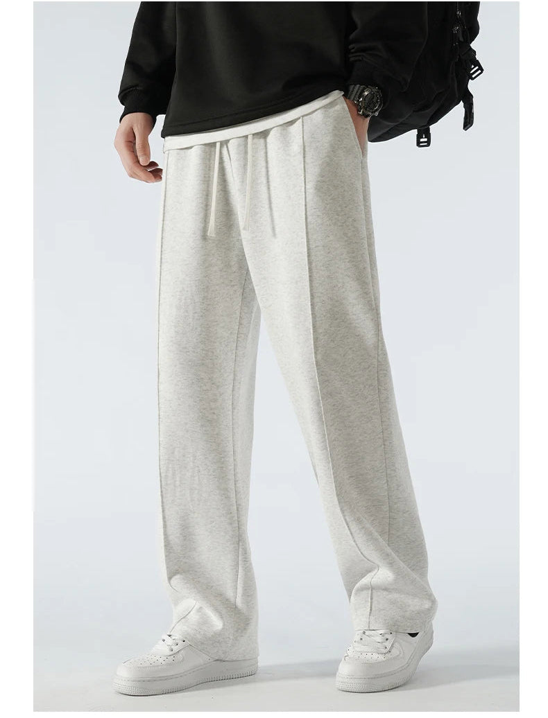 Person wearing light gray wide-leg pants with a plain background